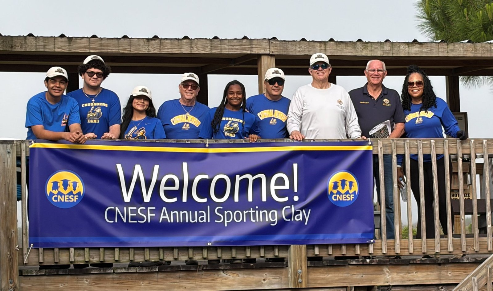 CNESF volunteers and Cardinal Newman Crusaders on a shooting station with a Welcome banner